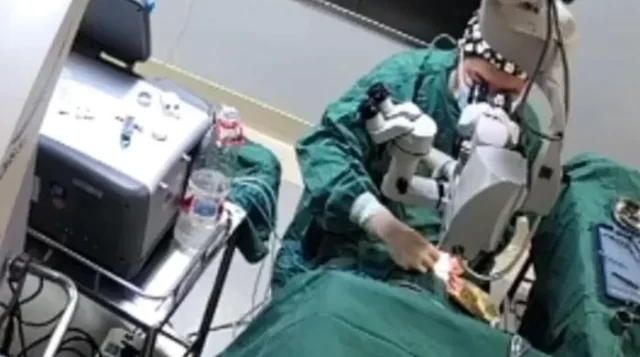 Shocking moment doctor PUNCHES patient in the face while performing surgery on her eyes